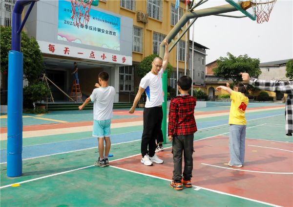 黃鷹帶領(lǐng)孩子們鍛煉。譚燕攝