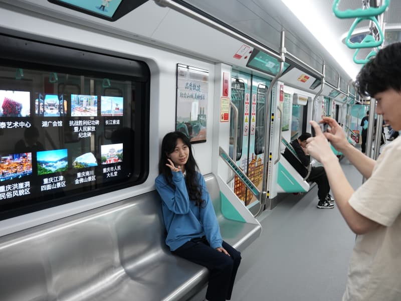 乘客打卡重慶軌道交通18號線智慧車窗。謝茂攝