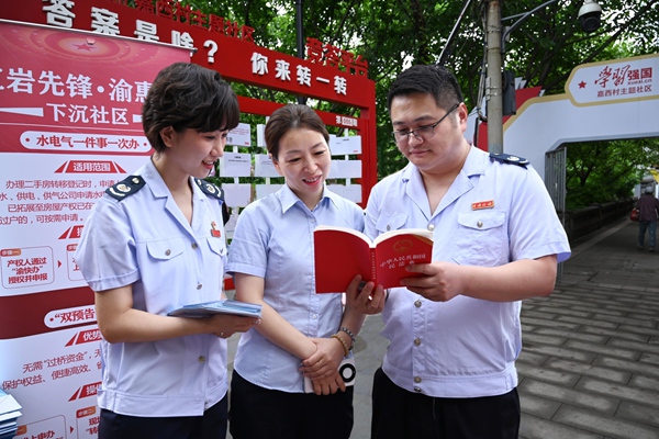 稅務(wù)總局駐重慶特派辦和渝中區(qū)稅務(wù)局工作人員在嘉西村主題社區(qū)為市民介紹民法典相關(guān)內(nèi)容。徐佑君攝