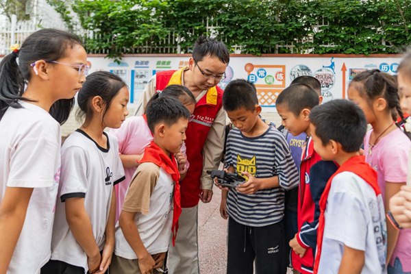 青年志愿者指導(dǎo)學(xué)生們體驗無人機操作。國網(wǎng)重慶永川供電公司供圖