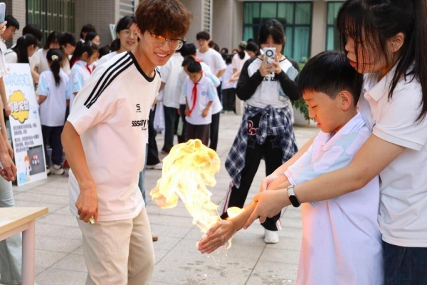 小朋友們在室外廣場體驗“火焰掌”實驗。重慶師范大學供圖