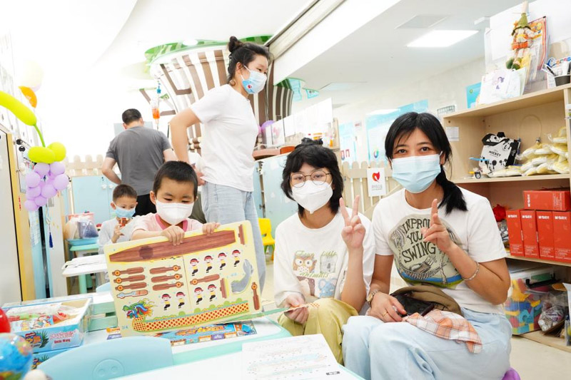 兒童病房學(xué)校里，孩子們和家長(zhǎng)一起拼龍舟模型。