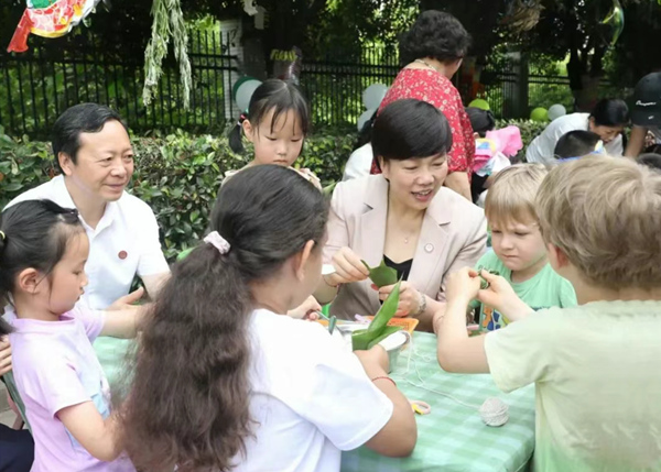 重慶師范大學(xué)黨委書記張艷與孩子們一起包粽子。重慶師范大學(xué)附屬幼兒園供圖