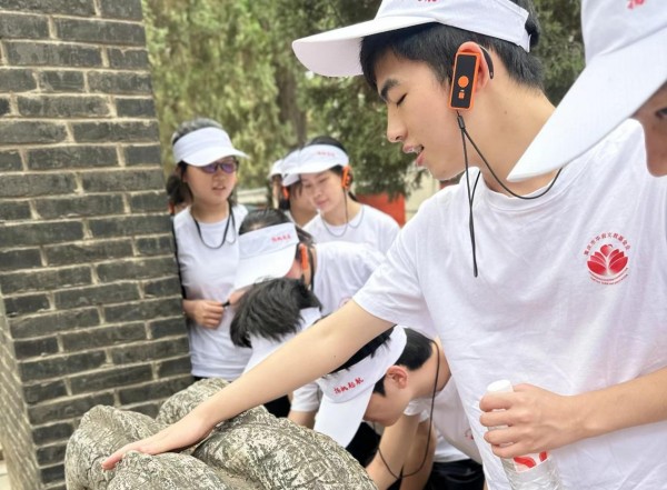 學子觸摸古文物。主辦方供圖