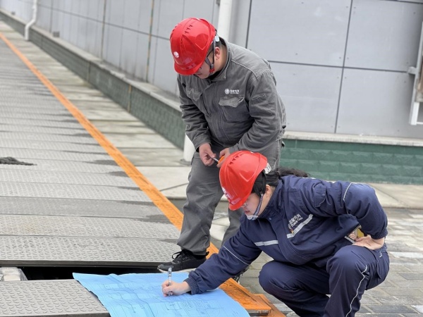 國網(wǎng)重慶經(jīng)研院技經(jīng)中心員工正在測量站內(nèi)電纜溝尺寸。國網(wǎng)重慶經(jīng)研院供圖