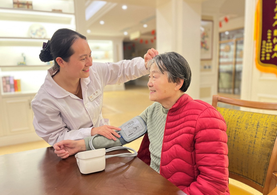 渝北一養(yǎng)老機構(gòu)護理員為老人測量血壓，了解老人健康狀況。張寶合攝