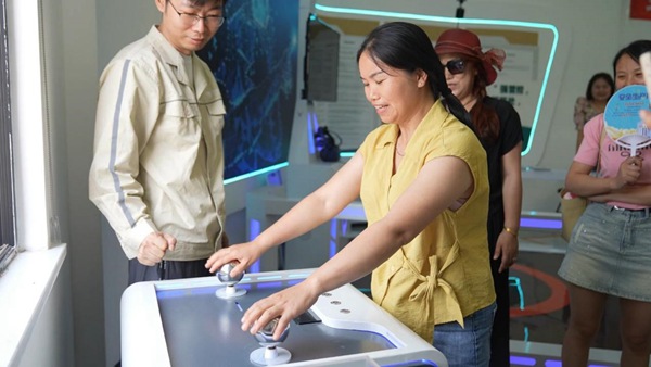 員工家屬親身感受觸電模擬試驗(yàn)。國(guó)網(wǎng)重慶永川供電公司供圖