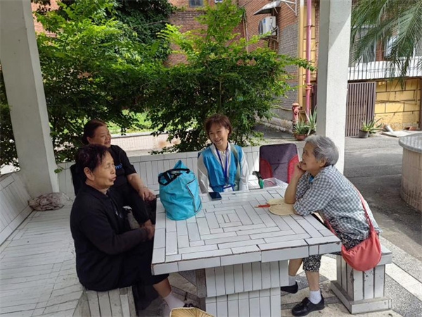 網(wǎng)格員李春梅宣傳相關(guān)工作政策。受訪者供圖