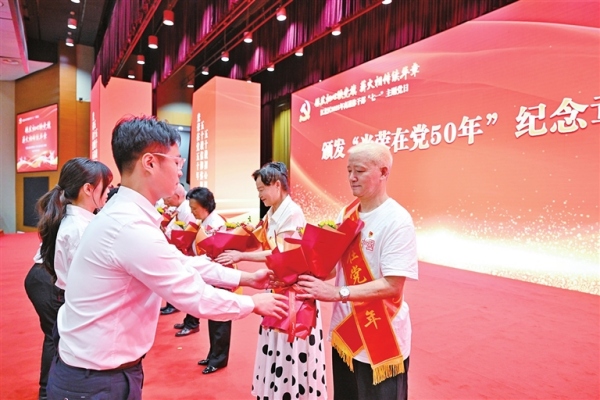 為“光榮在黨50年”老黨員獻花。林豪攝