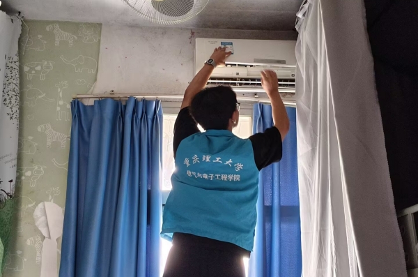志愿者正在取下空調(diào)濾網(wǎng)。重慶理工大學(xué)供圖