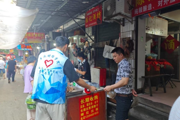 志愿者給商戶發(fā)放反詐傳單。重慶財經(jīng)學(xué)院供圖