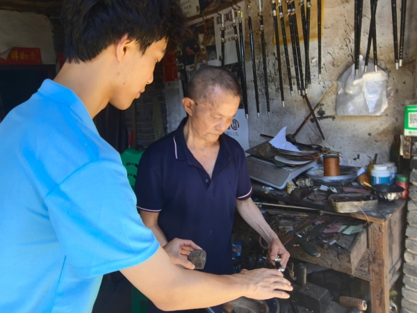 服務隊成員采訪手工木秤制作者王澤喜老人。重慶財經(jīng)學院供圖