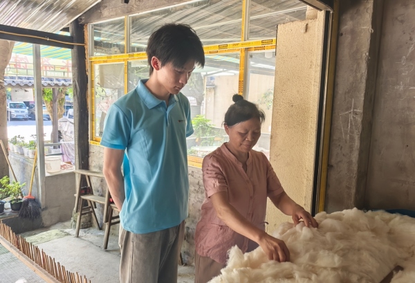 服務隊成員采訪棉被手藝人。重慶財經(jīng)學院供圖