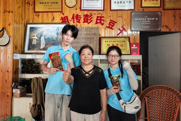 服務隊成員與彭氏豆干傳承人合影。重慶財經(jīng)學院供圖