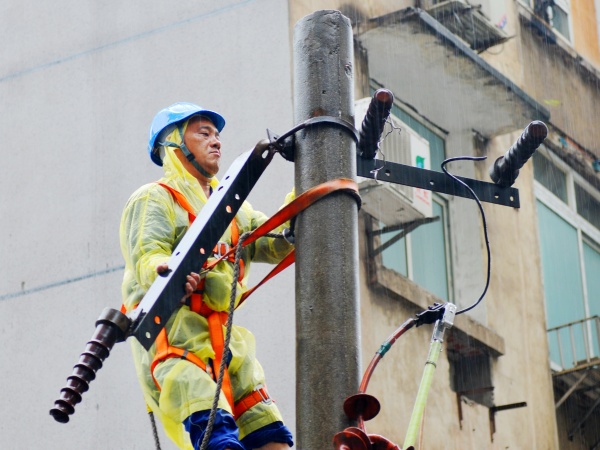 國網(wǎng)重慶市區(qū)供電公司搶修人員冒雨對10千伏沙北街柱上變壓器進(jìn)行搶修。韓薇攝