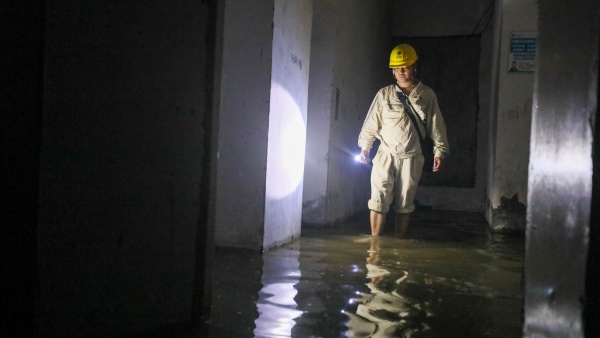 國網(wǎng)重慶市南供電公司員工在巴南區(qū)小灣家園涉水巡視配電設(shè)施。龔超攝
