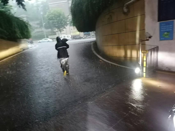 招商依云江灣物業(yè)工作人員正緊急運送防汛沙袋封堵車庫入口，防止雨水倒灌。招商積余重慶公司供圖