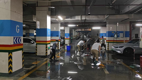 保利花半里小區(qū)物業(yè)工作人員清理車庫積水。保利物業(yè)重慶公司供圖