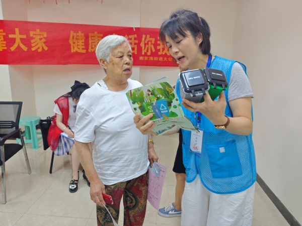 工作人員通過垃圾分類彩頁、模型等向老年人講解垃圾分類知識。呂麗珊攝