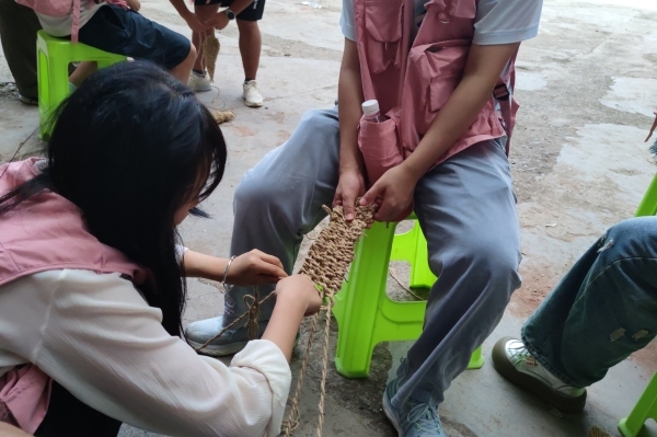 團(tuán)隊(duì)成員體驗(yàn)編草鞋。重慶移通學(xué)院供圖