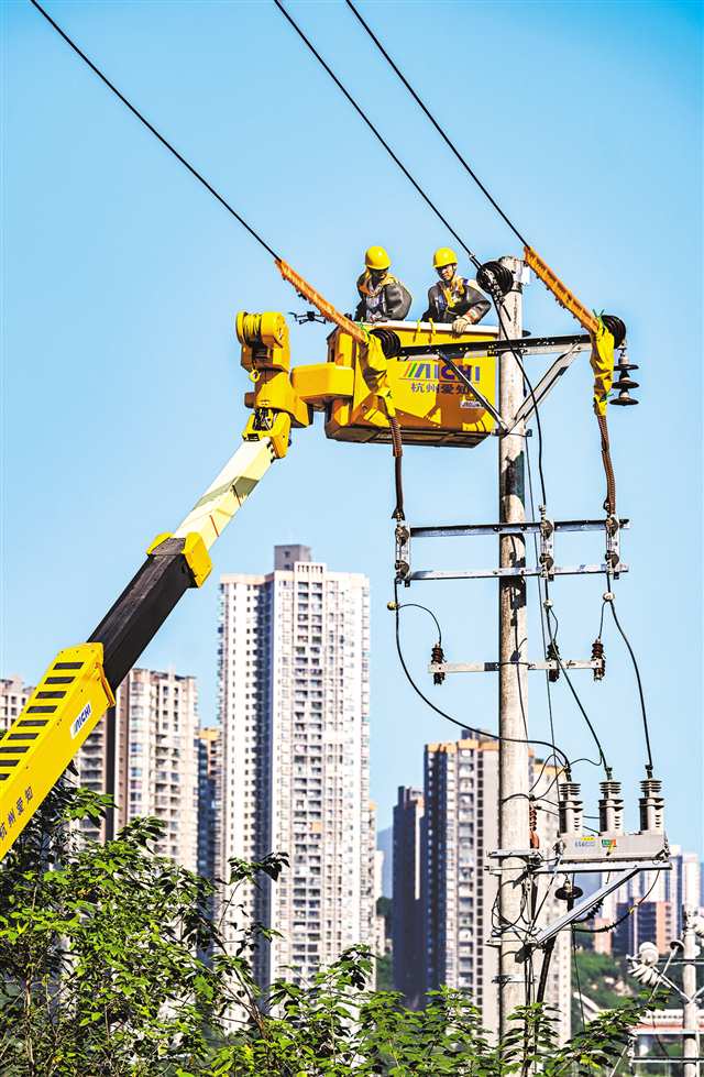 七月十五日，江北區(qū)北濱一路，電力工人正在開(kāi)展帶電搭頭作業(yè)。首席記者 龍帆 實(shí)習(xí)生 王逍楊 攝\視覺(jué)重慶