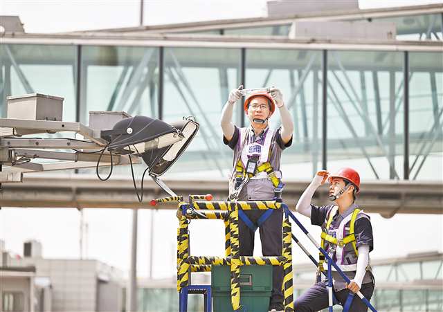 7月17日，重慶江北國際機(jī)場停機(jī)坪，助航燈光維護(hù)員更換高桿燈的燈管。（本組圖片由記者羅斌攝/視覺重慶）