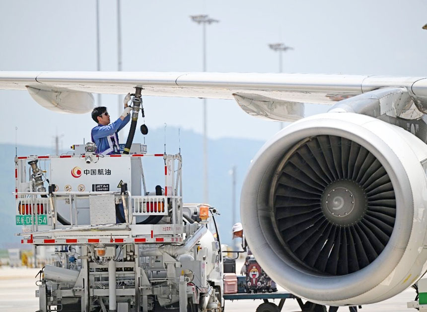 7月17日，重慶江北國際機(jī)場停機(jī)坪，飛機(jī)加油員朱森在飛機(jī)發(fā)動機(jī)旁工作。