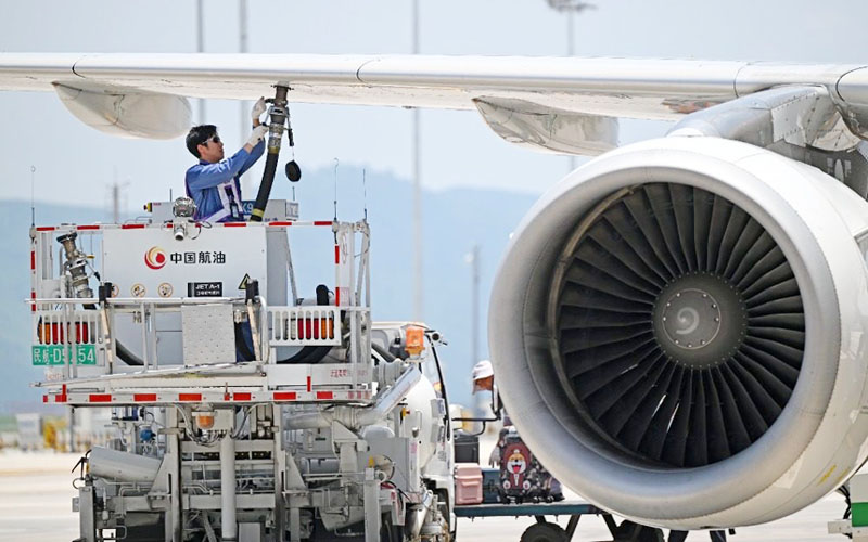7月17日，重慶江北國際機(jī)場停機(jī)坪，飛機(jī)加油員朱森在飛機(jī)發(fā)動機(jī)旁工作。