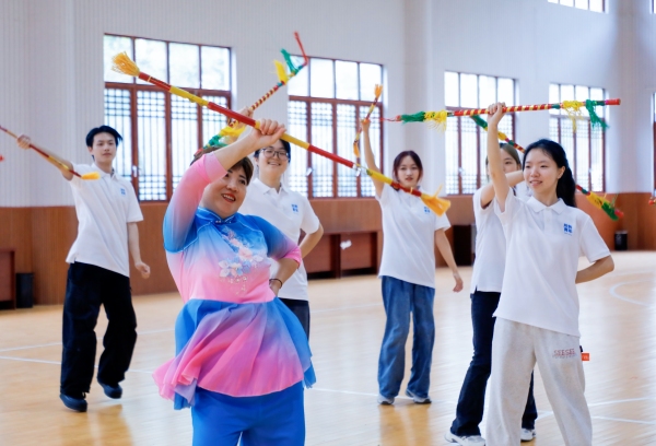 實踐團(tuán)向吳昌春學(xué)習(xí)錢棍舞基本動作。盧力攝