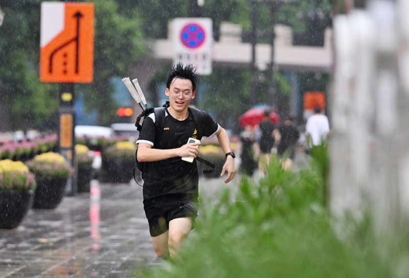 2025年7月18日，渝中區(qū)白象街，市民在雨中奔跑。首席記者 龍帆 攝