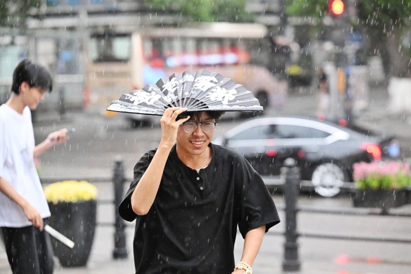 7月18日，渝中區(qū)白象街，市民冒雨前行。首席記者 龍帆 攝