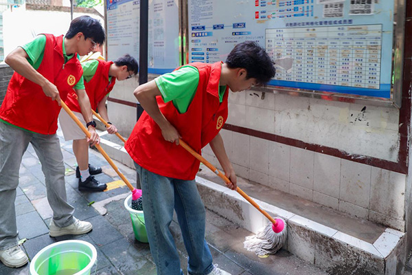 清掃小區(qū)環(huán)境。重慶電力高等?？茖W(xué)校供圖