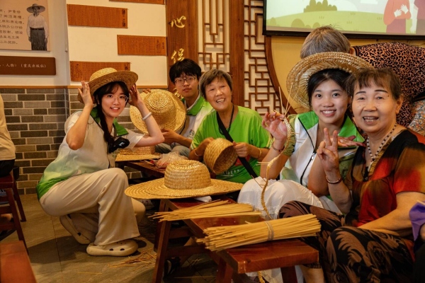 團(tuán)隊(duì)成員與回龍壩鎮(zhèn)老人一起編織草帽。甘世杰攝