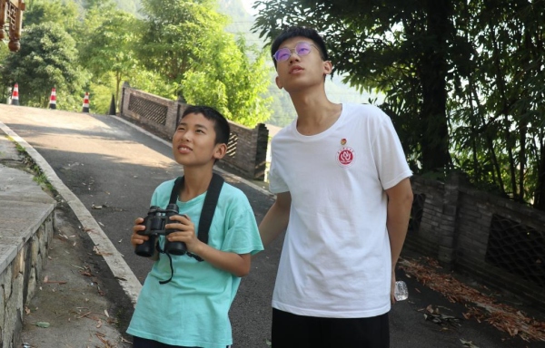 服務(wù)團(tuán)成員帶領(lǐng)小朋友戶外觀鳥。重慶師范大學(xué)供圖