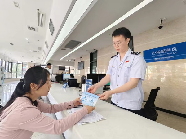 潼南區(qū)稅務(wù)人員為企業(yè)財務(wù)人員發(fā)放“成渝納稅信用修復(fù)提示卡”，引導(dǎo)其及時更正涉稅失信行為。周歡攝