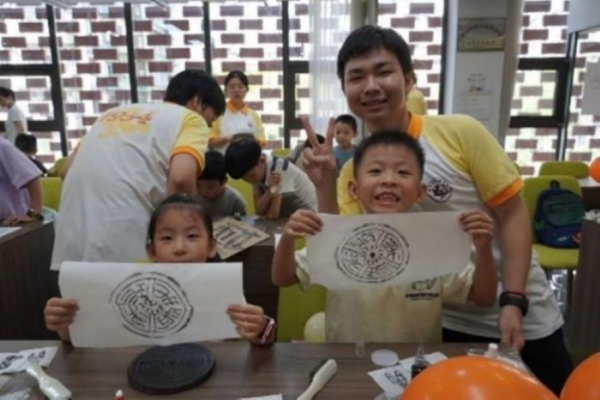 團(tuán)隊成員指導(dǎo)小朋友體驗拓印。重慶師范大學(xué)供圖