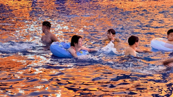 游客在晚霞映照的水面戲水。景區(qū)供圖