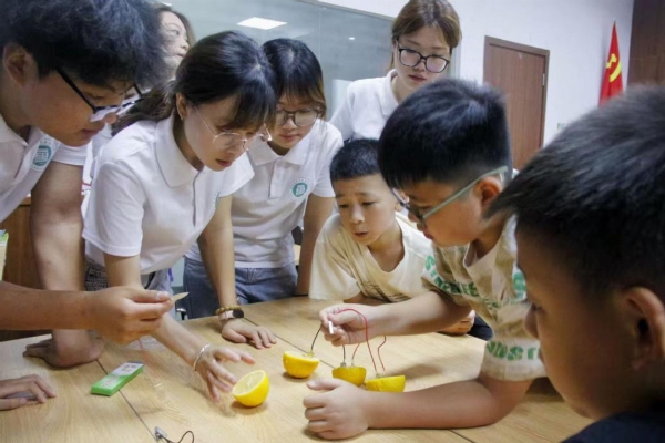 踐行團(tuán)成員指導(dǎo)小朋友進(jìn)行水果發(fā)電實(shí)驗(yàn)。重慶電力高等?？茖W(xué)校供圖