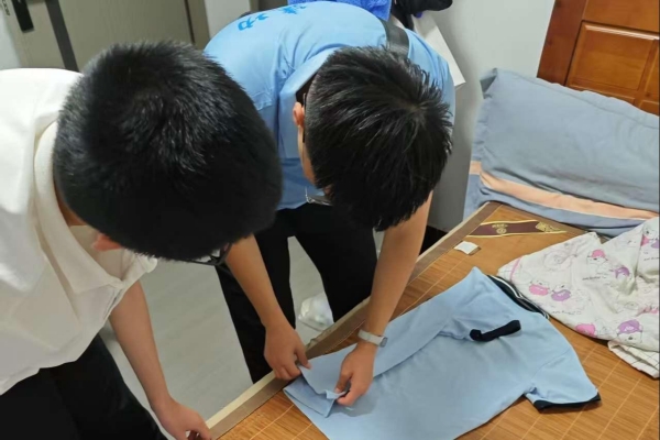 志愿者指導(dǎo)小朋友整理衣物。重慶理工大學(xué)供圖