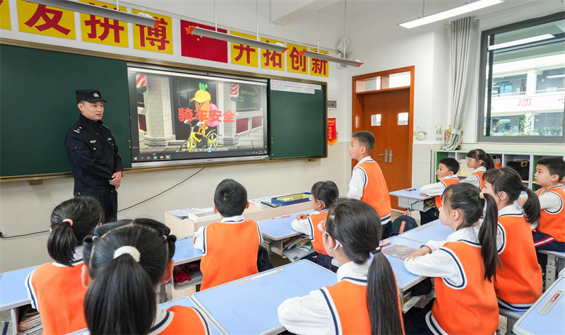 桂陽(yáng)街道民警為西湖小學(xué)的學(xué)生講解交通安全。墊江縣融媒體中心供圖 第1眼TV-華龍網(wǎng)發(fā)