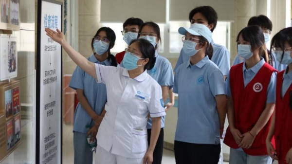 護(hù)士長(zhǎng)為志愿者講解醫(yī)院數(shù)理醫(yī)學(xué)運(yùn)用。重慶理工大學(xué)供圖