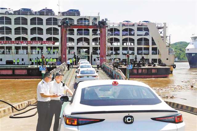 “重慶造”汽車排隊上滾裝船，重慶海關(guān)關(guān)員開展現(xiàn)場核查。（受訪者供圖）