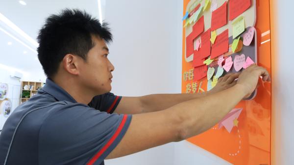 快遞小哥將心愿貼上“騎士心愿墻”。楊妮沙攝