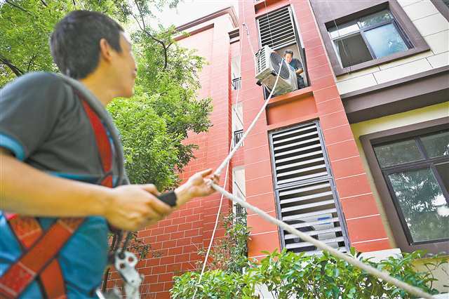 8月5日，南坪實(shí)驗(yàn)金科小學(xué)，工人正在吊裝空調(diào)外機(jī)。近日，南岸區(qū)啟動(dòng)“清涼工程”，將為58所中小學(xué)校統(tǒng)一安裝空調(diào)共3650臺(tái)。記者 謝智強(qiáng) 攝/視覺(jué)重慶