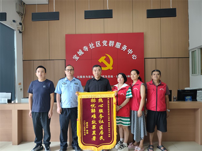 居民廖先生為寶城寺社區(qū)民警、網(wǎng)格員送錦旗致謝。通訊員 王軒 攝