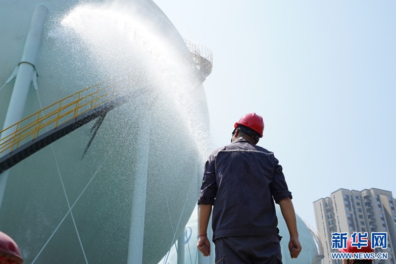 工作人員對(duì)球罐進(jìn)行噴水降溫。新華網(wǎng) 彭浩然 攝