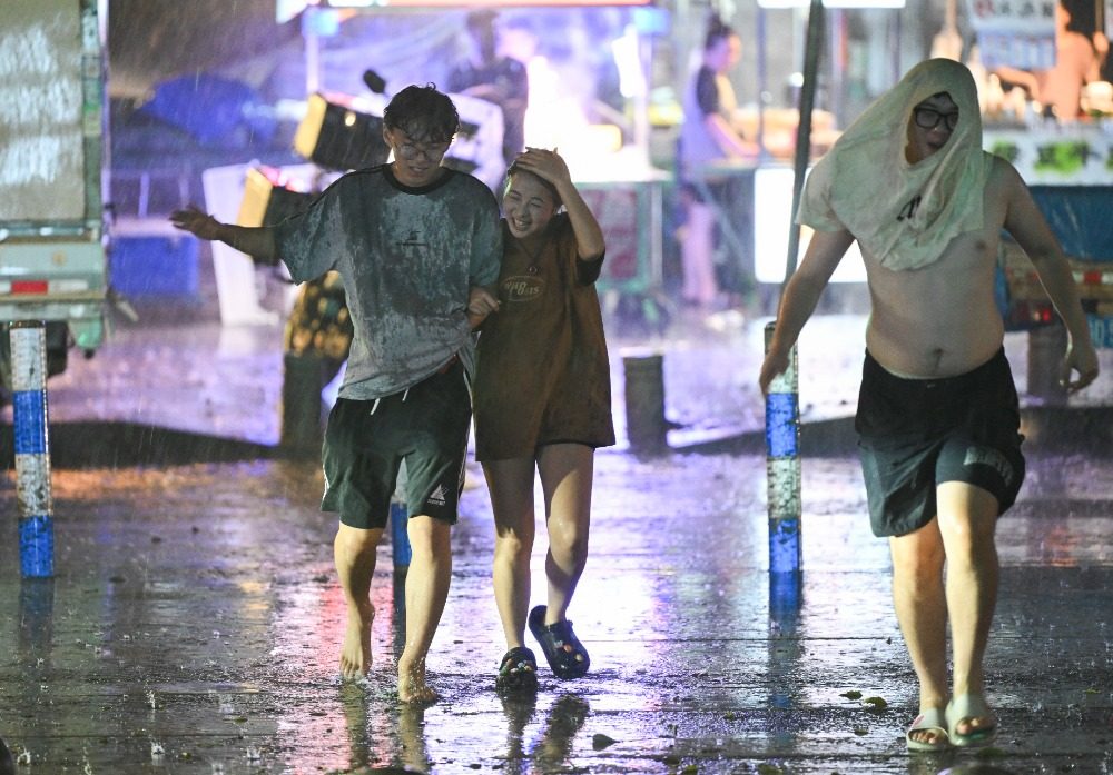 8月6日晚，南岸區(qū)水云路，市民開心地行走在暴雨中。記者 謝智強(qiáng) 攝