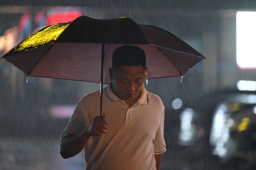 8月6日晚，南岸區(qū)水云路，市民行走在暴雨中。記者 謝智強(qiáng) 攝