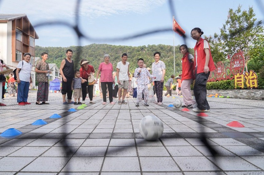 8月8日，在北碚區(qū)澄江鎮(zhèn)北泉村舉行的北碚區(qū)全民健身日主題活動(dòng)現(xiàn)場(chǎng)，村民們?cè)趨⒓佣c(diǎn)射門(mén)趣味運(yùn)動(dòng)項(xiàng)目。特約攝影 秦廷富