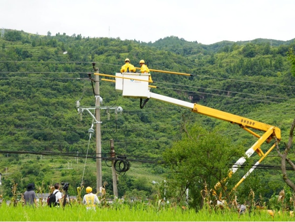 媒體記者在綦江區(qū)東溪鎮(zhèn)拍攝供電員工引流線搭接工作。袁巧攝